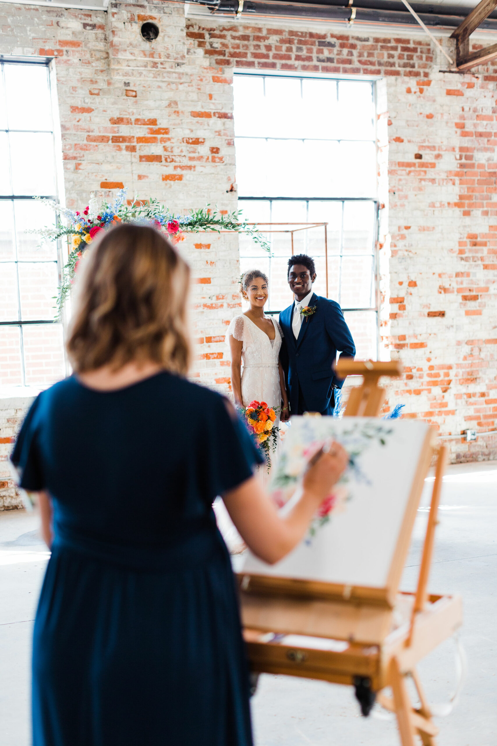 couple stand for live painting at wedding