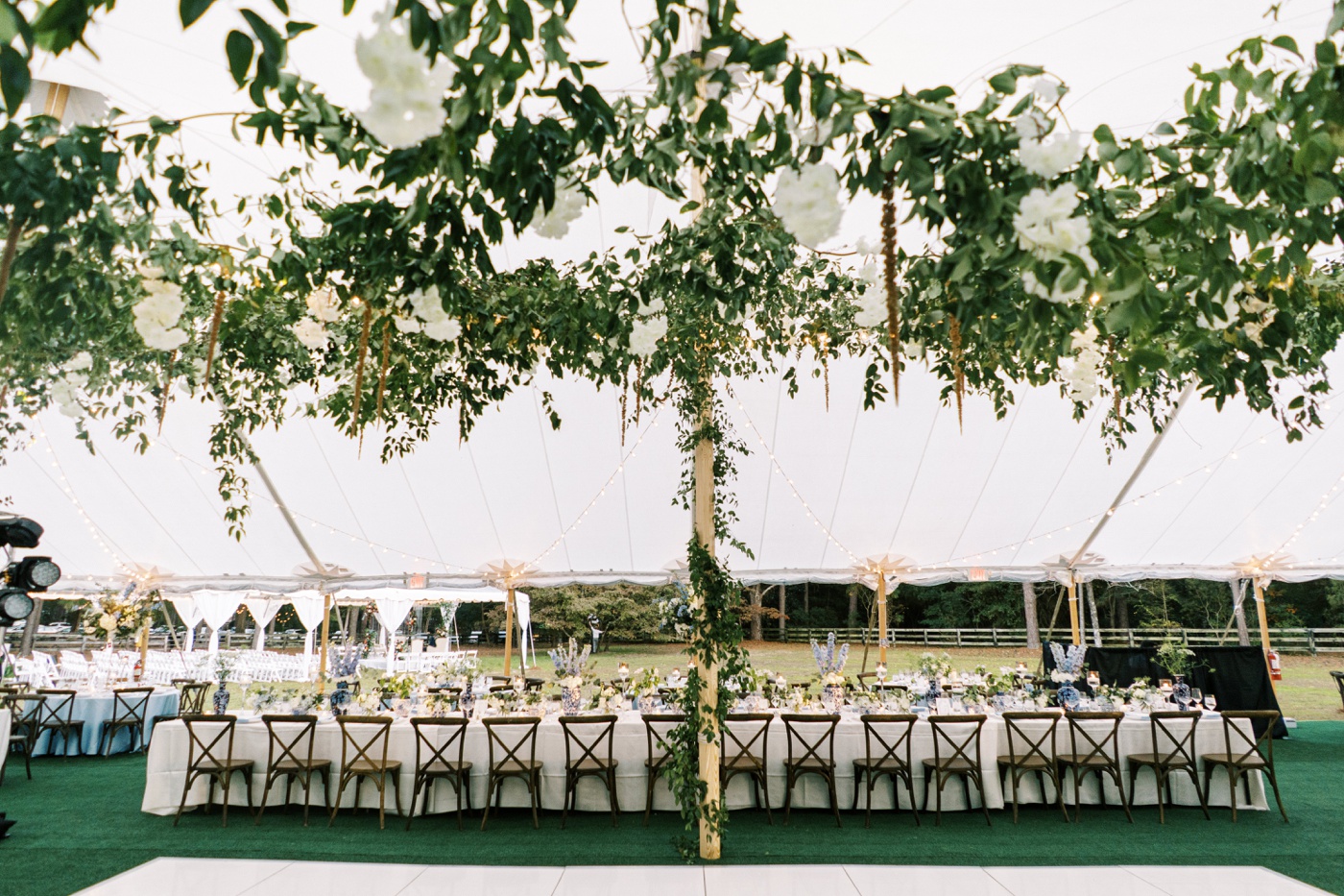 Outdoor tented reception featuring white tablecloths, Carolina blue napkins, and white and blue menus