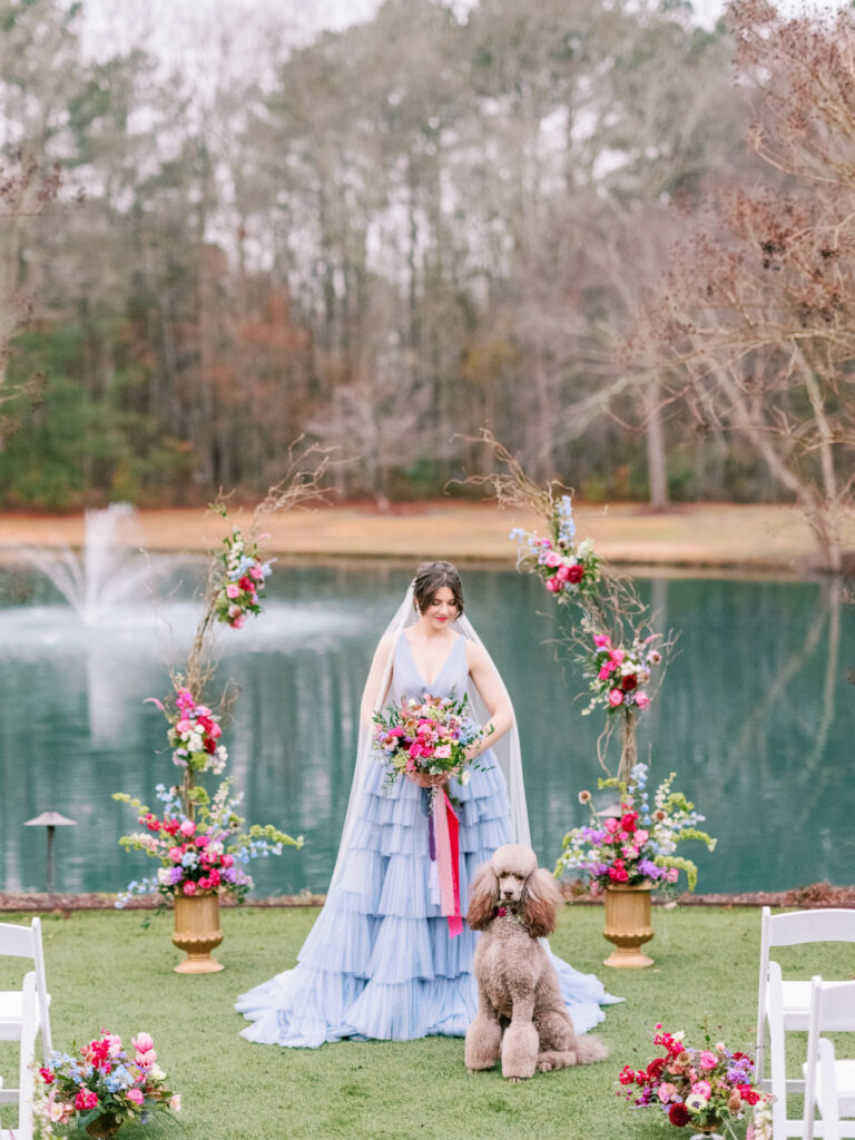 bride in blue wedding dress with color flowers at ceremony site