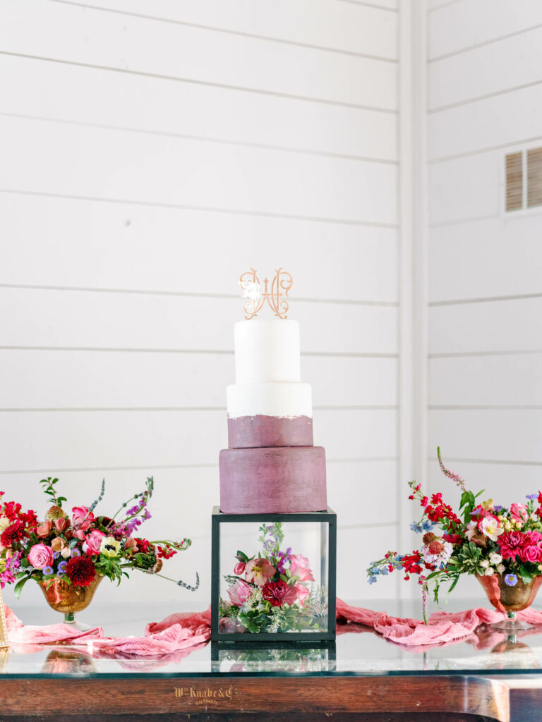 berry and pink wedding cake with custom acrylic monogram cake topper