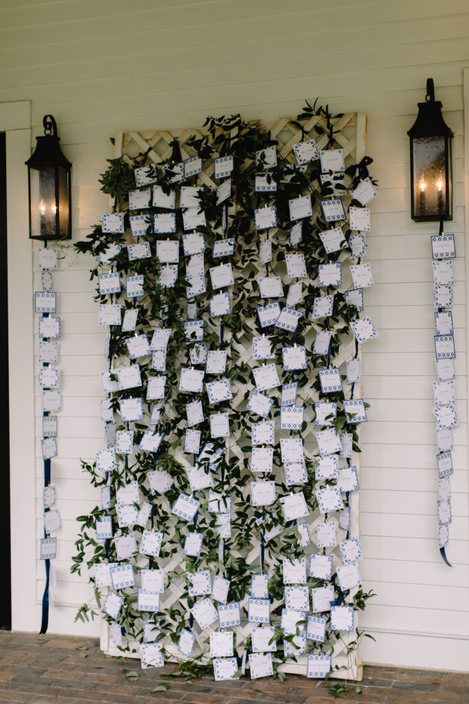 blue and white paper tile seating chart with greenery