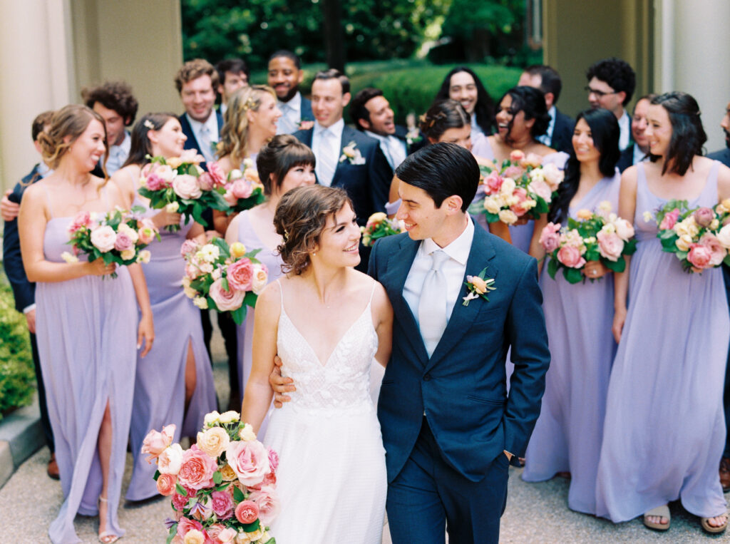 bridal party shot with groomsmen in navy suits and bridesmaids in lavender dresses
