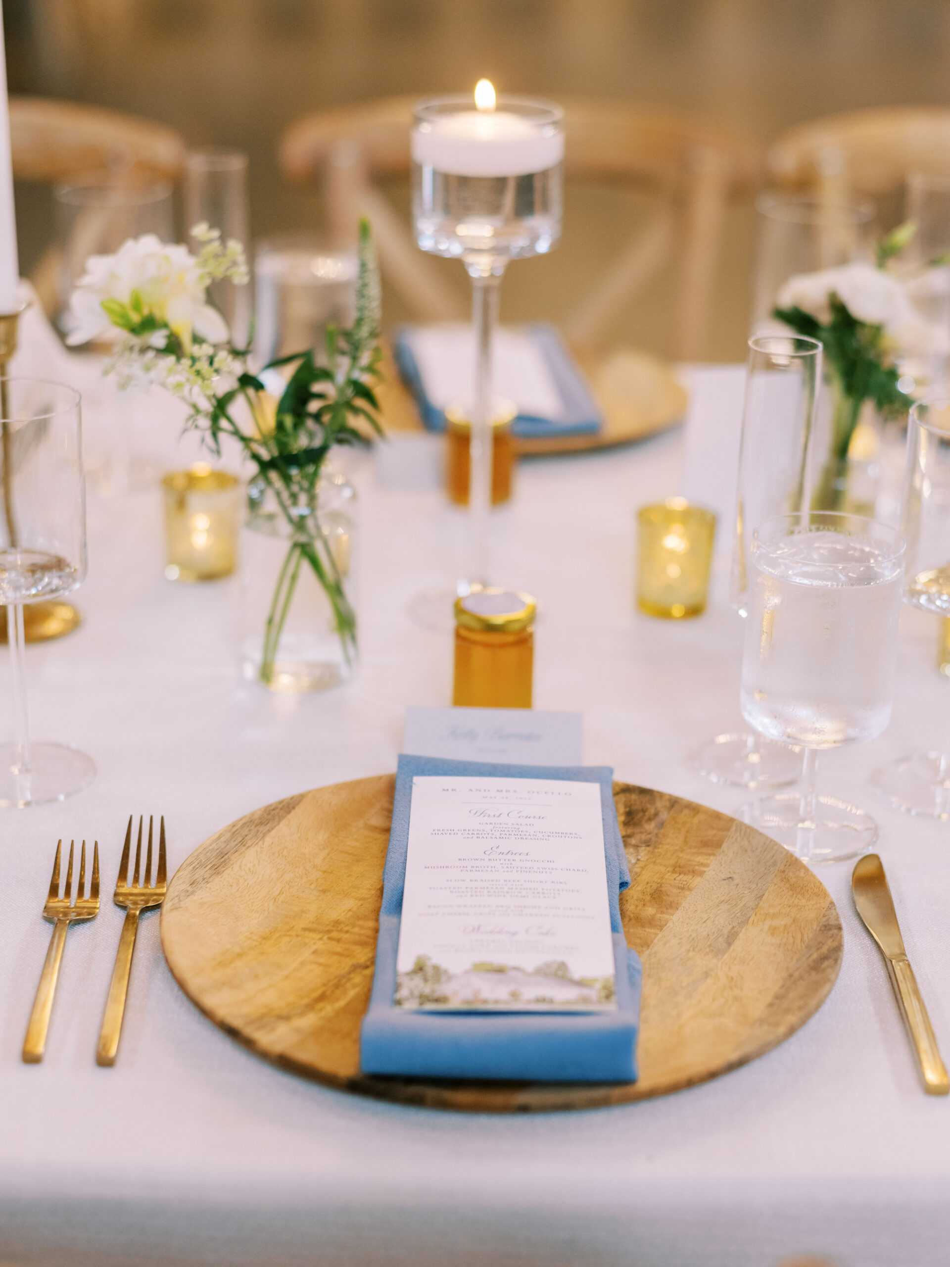wedding place setting with wooden charger blue napkin and dinner menu