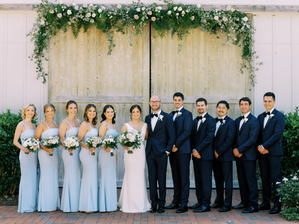 group bridal party shot in front of the barn of chapel hill