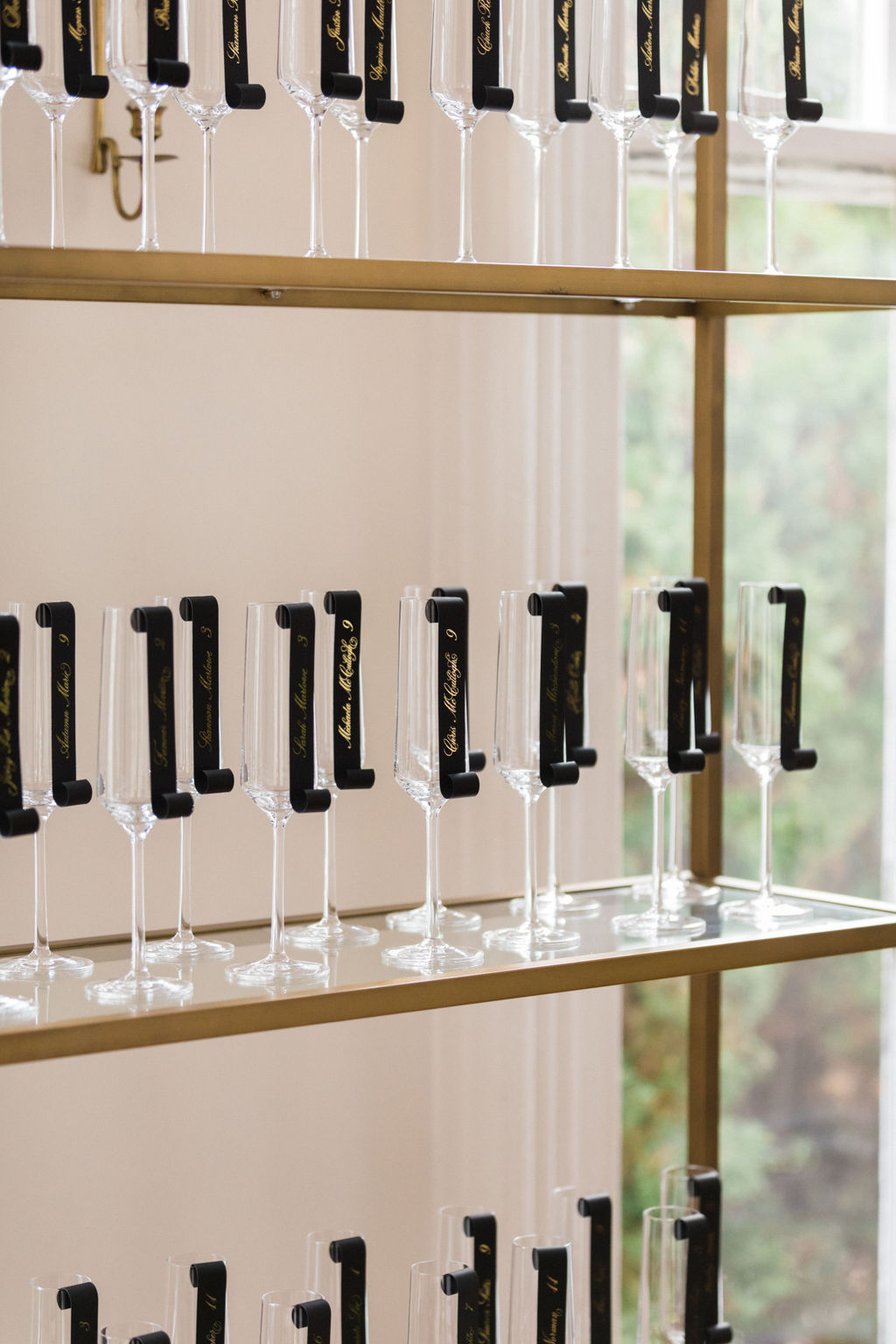 champagne flutes displayed at wedding with escort cards attached