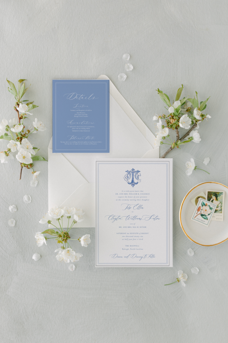 wedding monogram on invitation with flowers around envelope