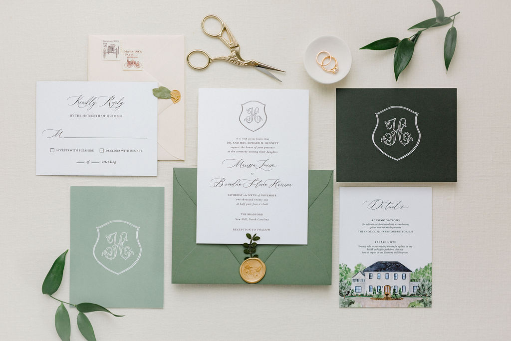 wedding invitation featuring the Bradford on details card and green envelopes with green leaves on table