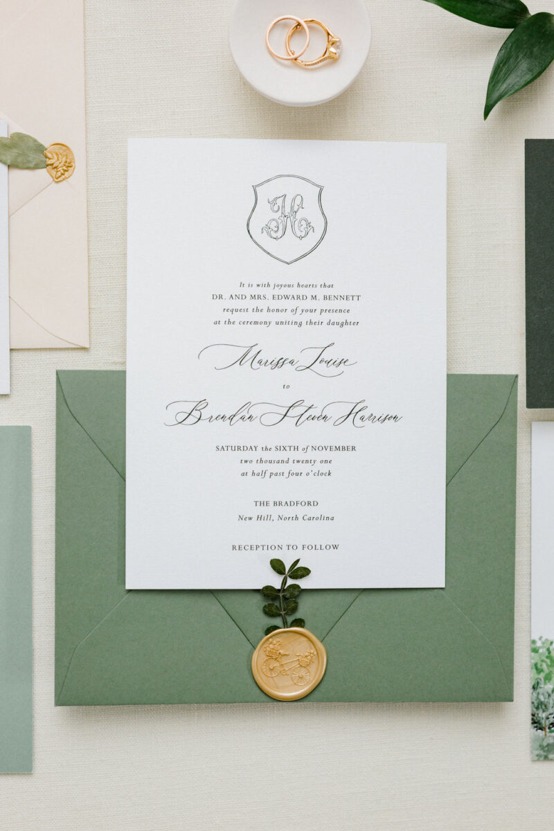 a green envelope with gold wax seal
