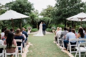 a couple gets married at Airlie gardens pergola garden with umbrellas