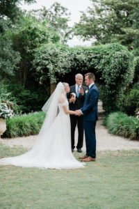 a couple exchanges vows in front of pergola garden