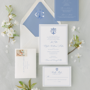 shuler studio blue and white monogram invitation on top of white envelope with blue envelope liner