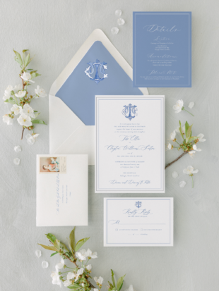shuler studio blue and white monogram invitation on top of white envelope with blue envelope liner
