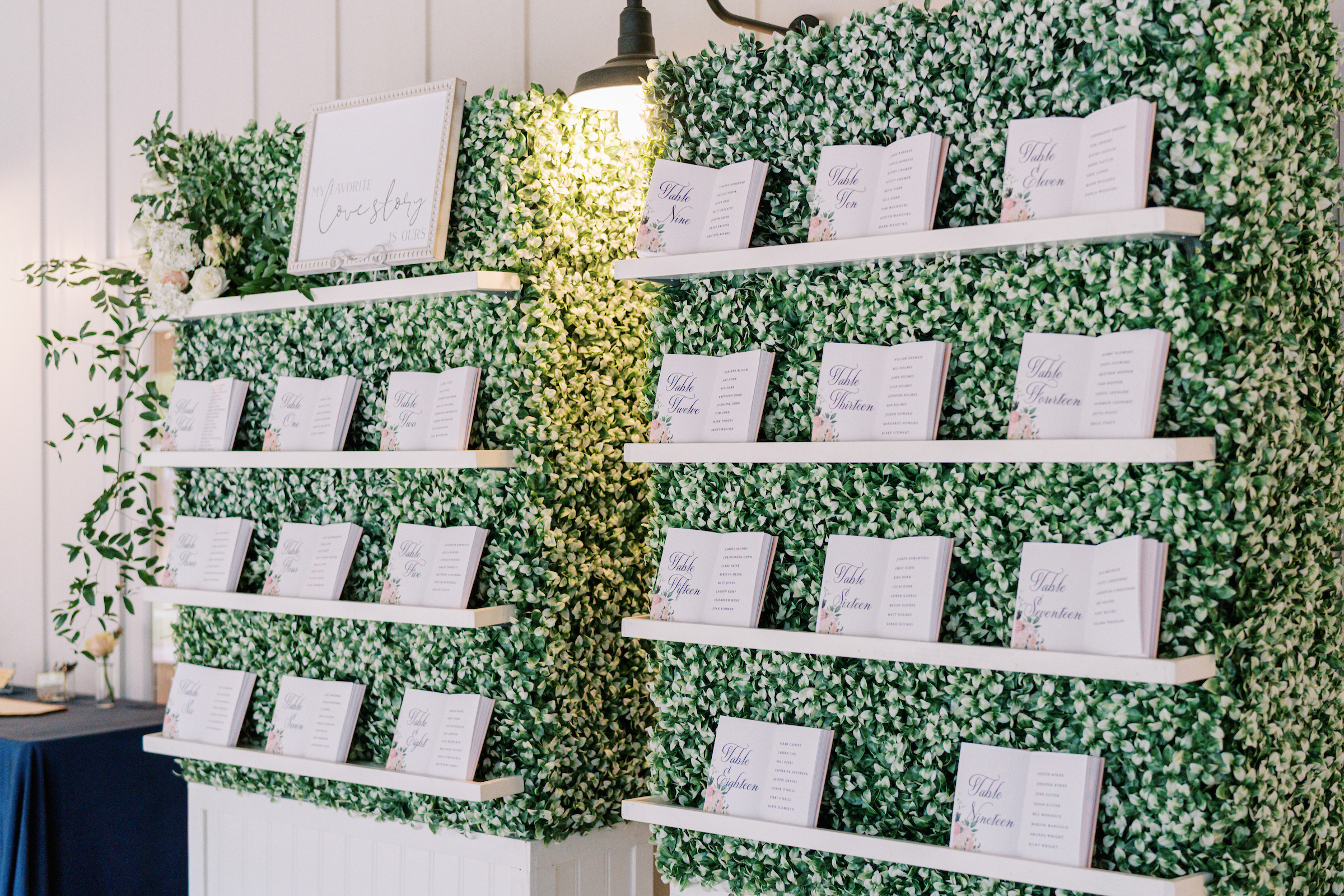 book seating chart on boxwood wall