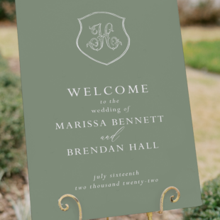 green wedding welcome sign on easel with crest