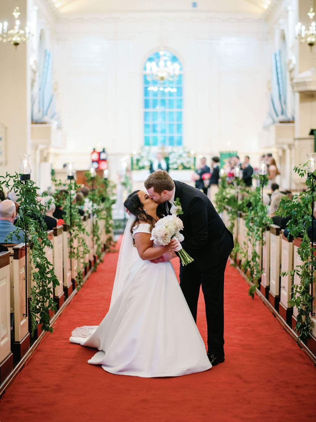 Couple kissing in aisle after getting married in chapel