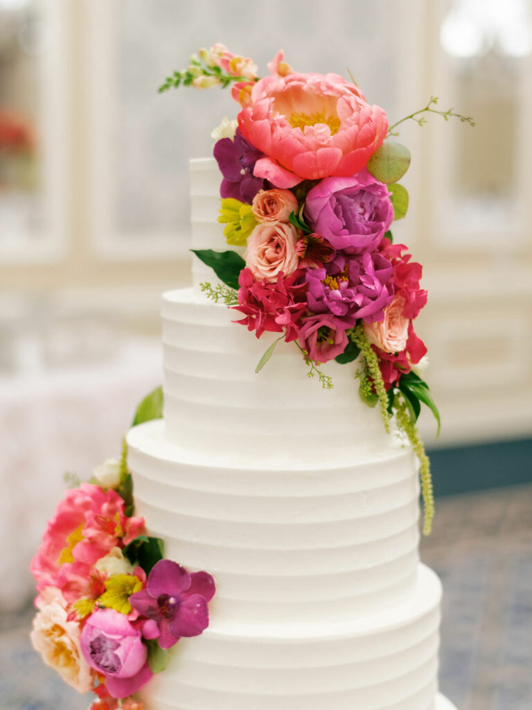 White wedding cake with bold colorful flowers