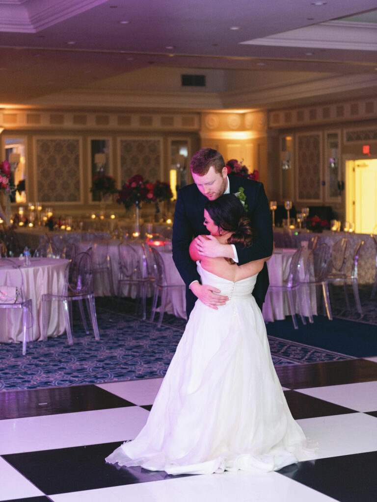 Couple shares last dance on black and white dance floor at their Pinehurst resort wedding