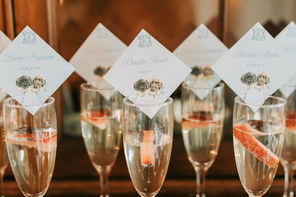 champagne display at wedding with customized escort cards with watercolor dogs