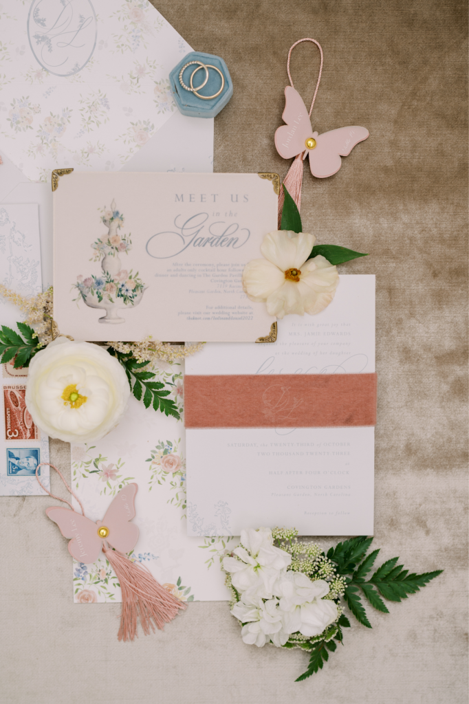 Stationer explains top trends for wedding stationery for 2023. Image shows flat lay for dainty wedding invitation suite.