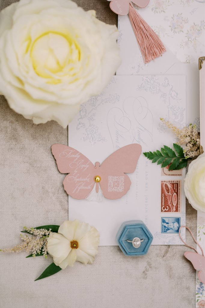 Stationer explains top trends for wedding stationery for 2023. Image shows flat lay for dainty wedding invitation suite.