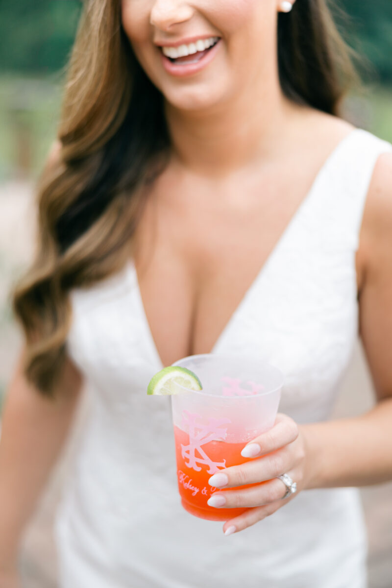 Shuler studio monogram cup with pink signature drink and lime in bride's hand