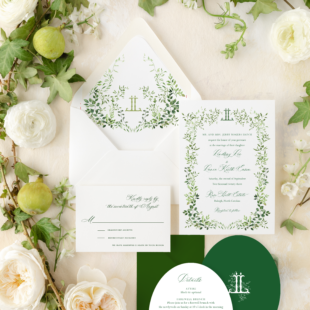 botanical watercolor greenery wedding invitation on white paper and green oval card with greenery around edges in a flatly