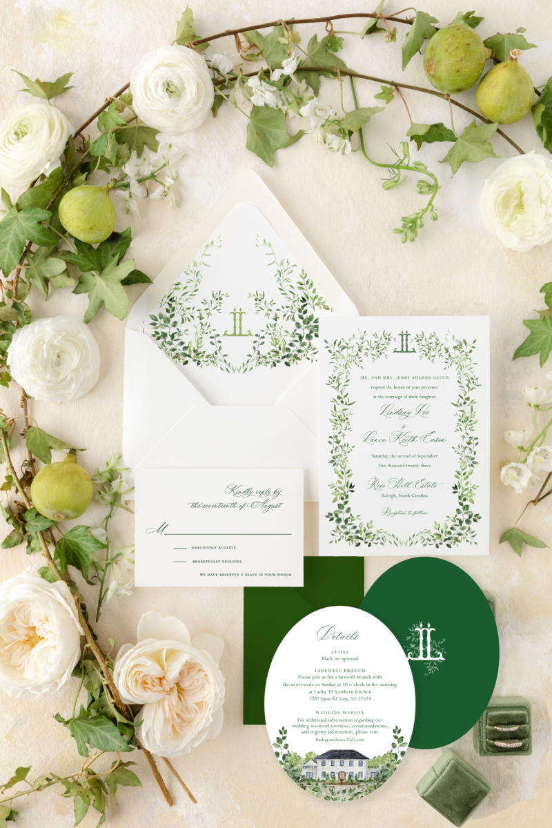 botanical watercolor greenery wedding invitation on white paper and green oval card with greenery around edges in a flatly