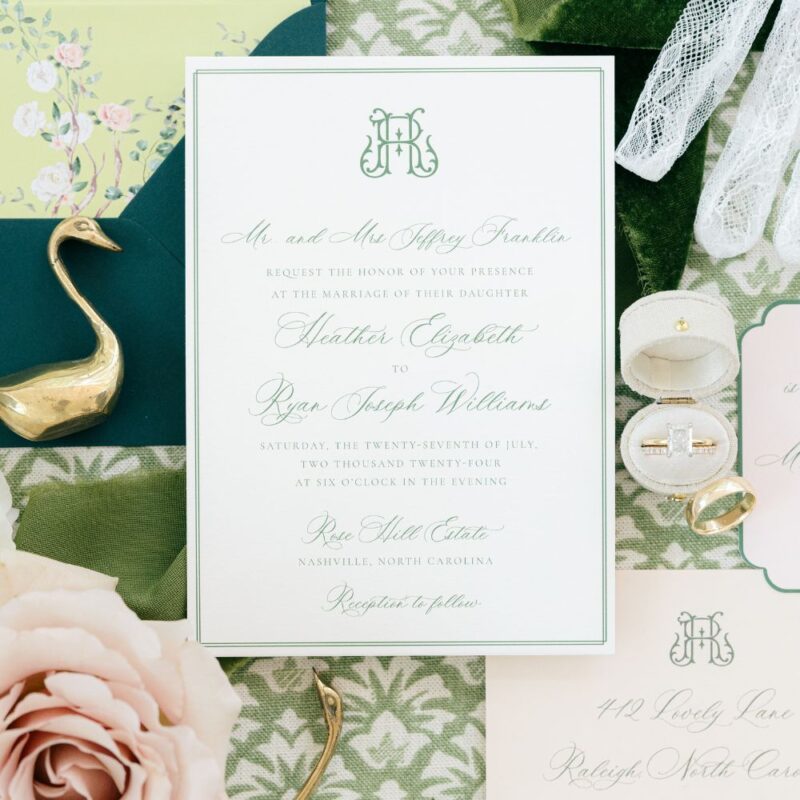 chinoiserie wedding stationery on green background with various Bridgeton inspired decorative objects