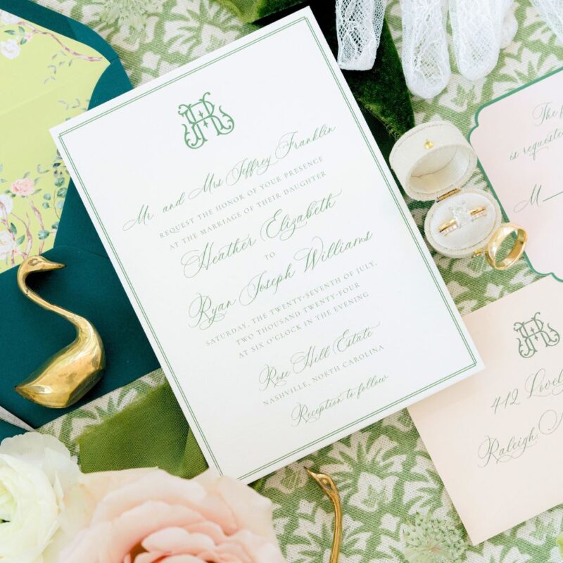 chinoiserie wedding stationery on green background with various Bridgeton inspired decorative objects