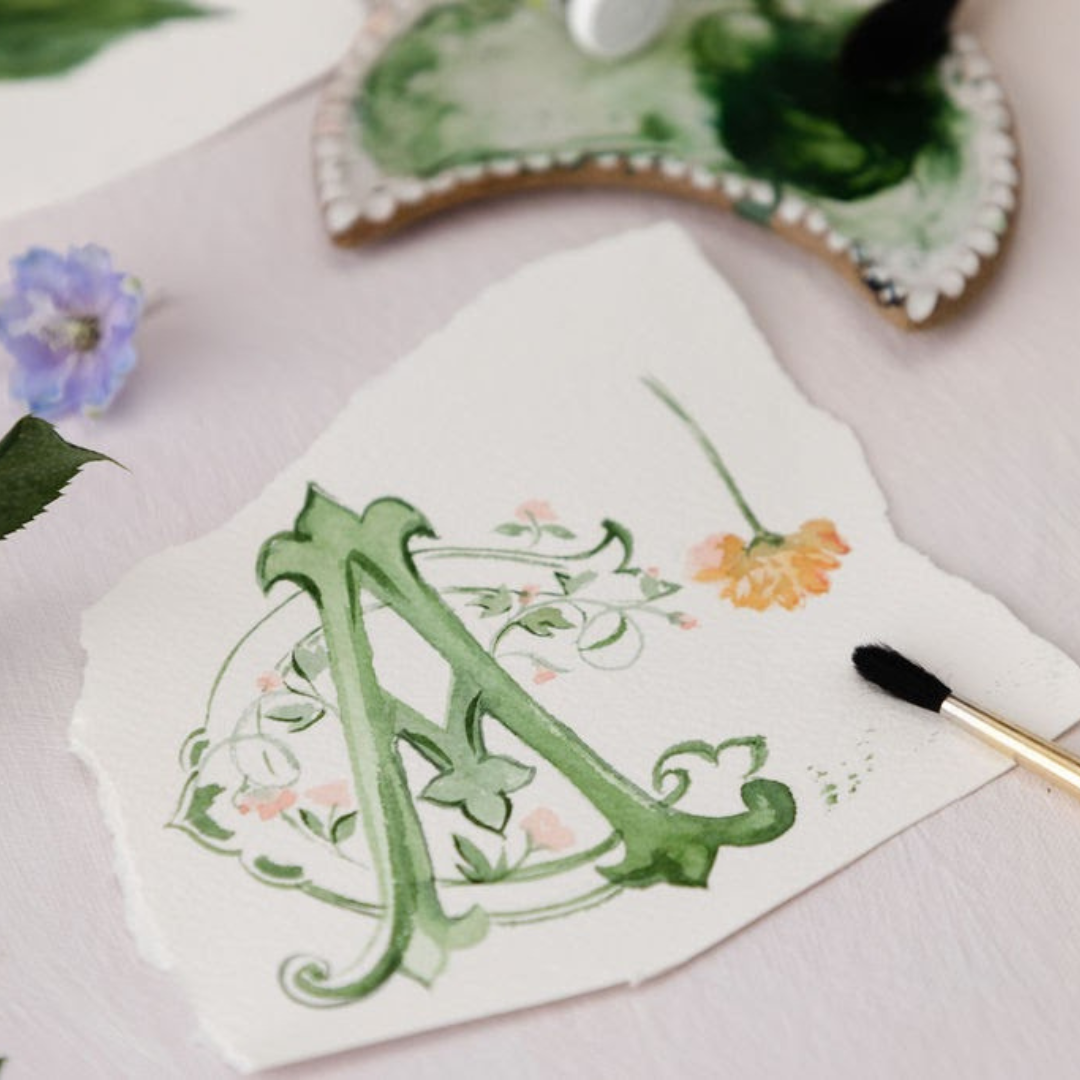 custom watercolor painted wedding monogram with paint brush and green paint palette
